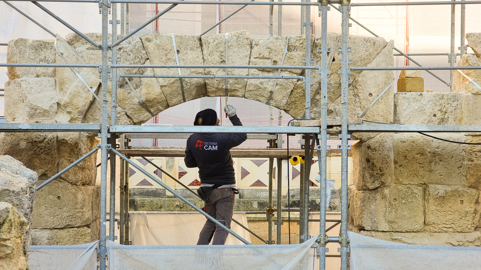 Person restoring historical building in Lecce. The structures of the building is consolidated with the patented CAM® active system.